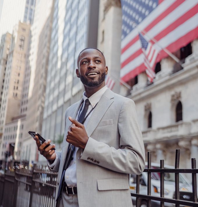 A business owner in a suit checking his phone in the financial district