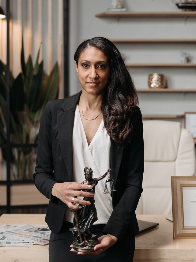 An attorney in her office holding an award